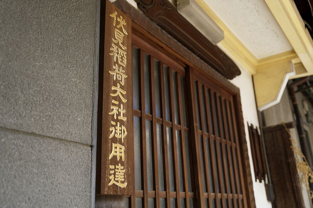 「伏見稲荷大社御用達」の看板が掲げられた事務所玄関