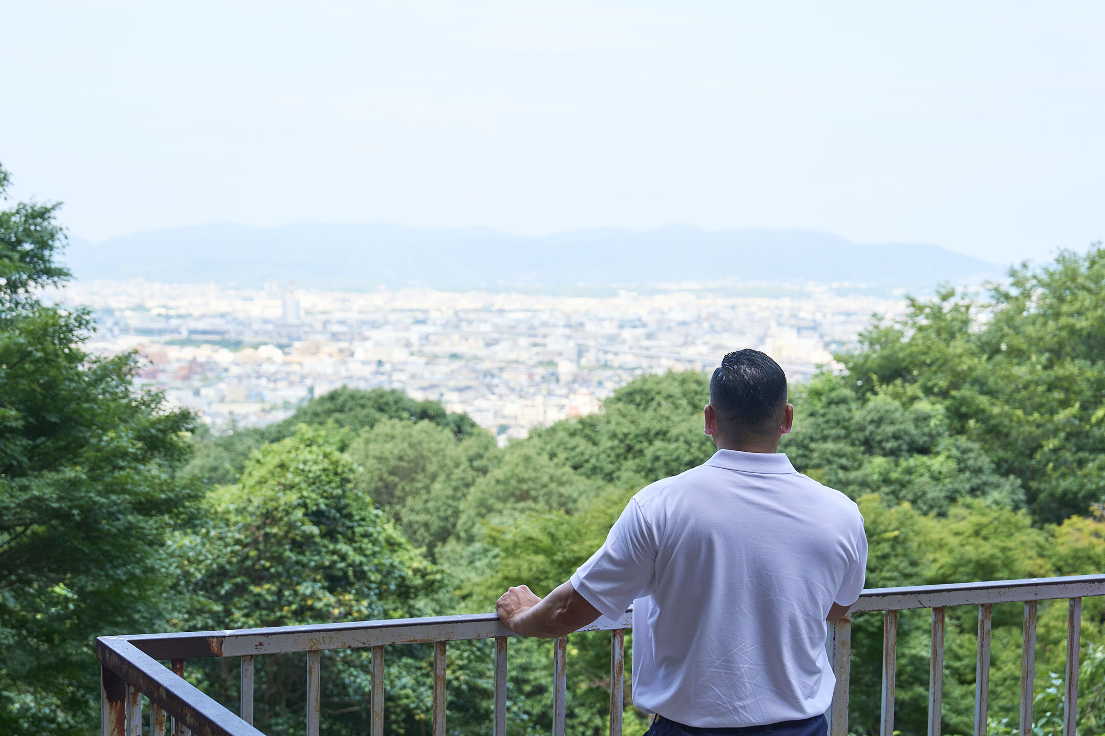京都市南西部の景色を眺める長谷川さんの後ろ姿