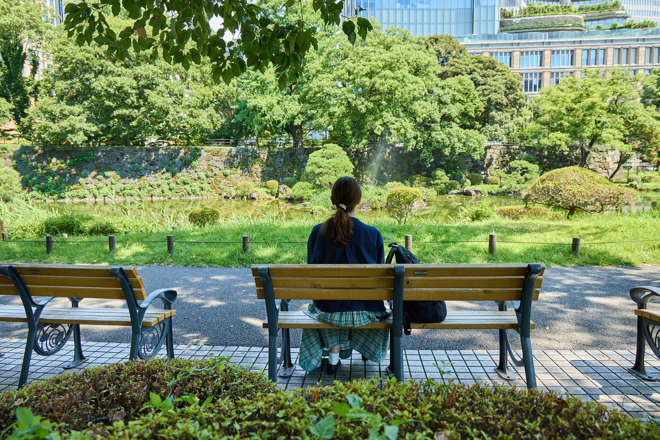 『日比谷公園』の心字池、ベンチに座り、景色を楽しむ髙谷さん