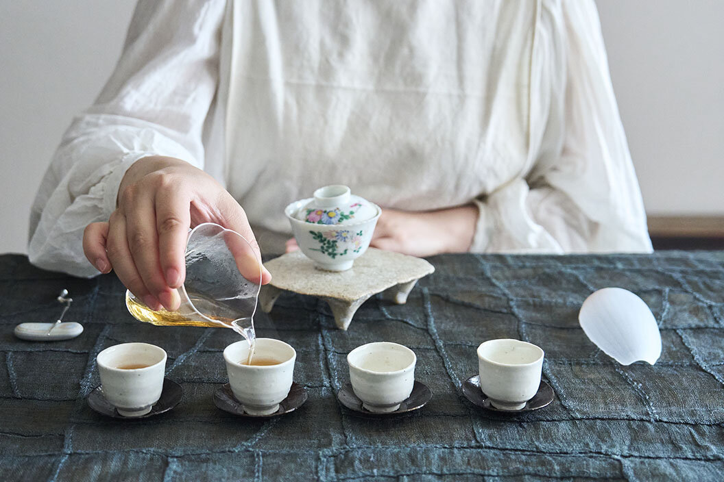 お茶をガラス製の公道杯に移し、茶杯に注ぎ分けているシンさん
