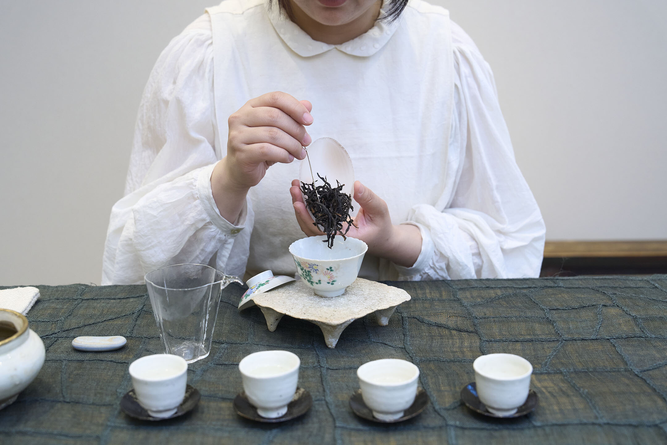 温めた蓋碗（がいわん）に青茶の茶葉を入れるシンさん