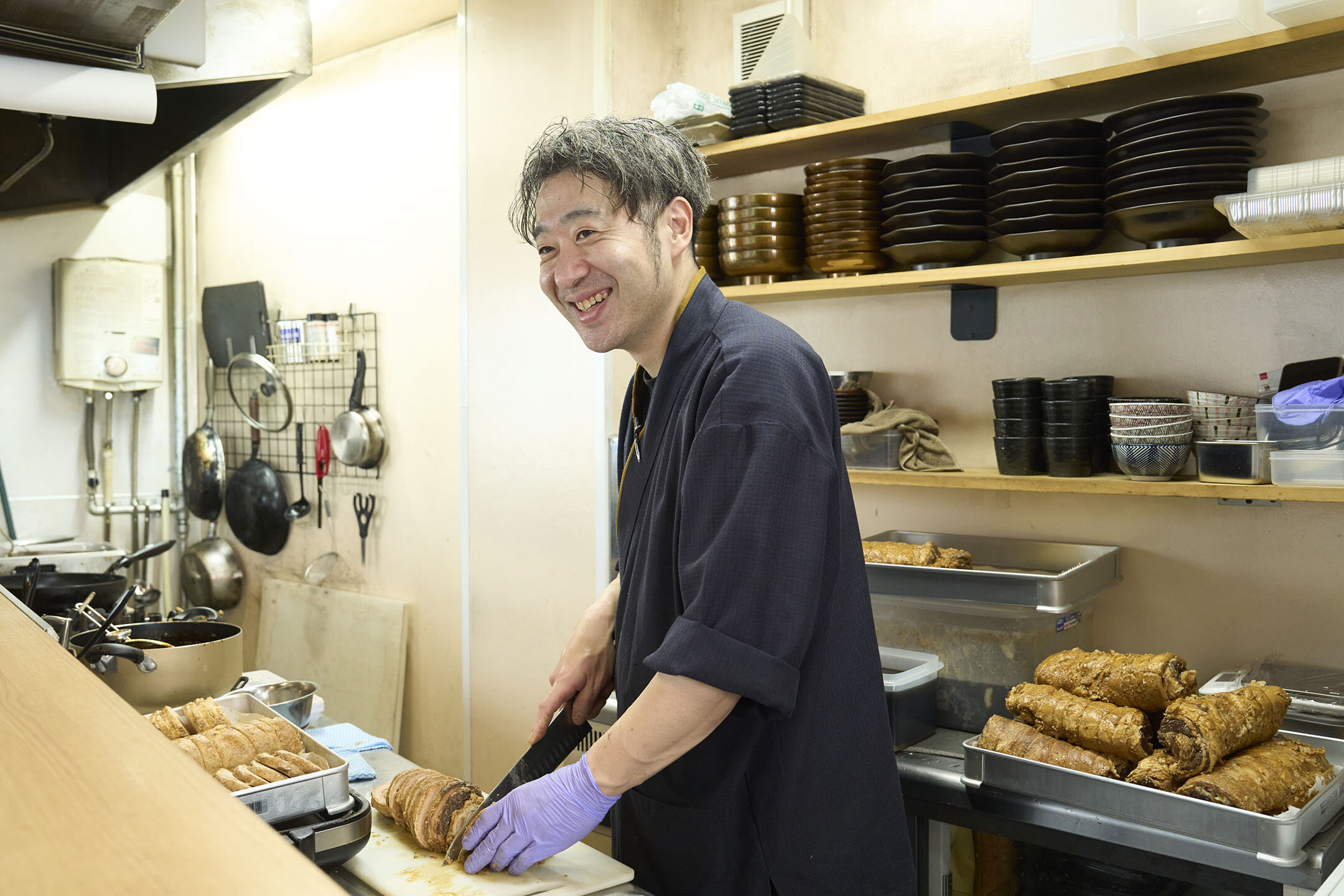 大量のチャーシューをカットしながら、笑顔で語ってくれる細見店長。