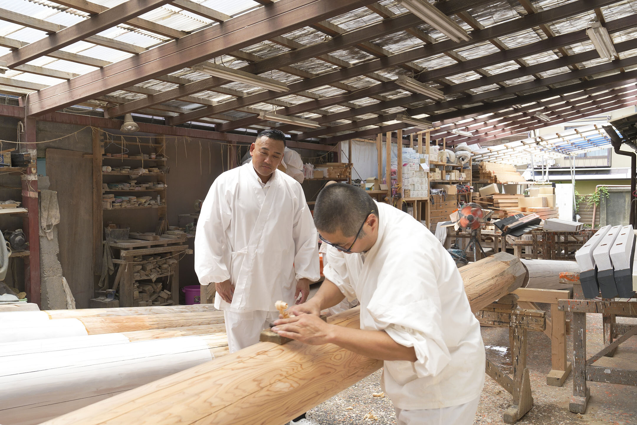 工房にて、丸かんなを使って円形に柱を削る職人さん