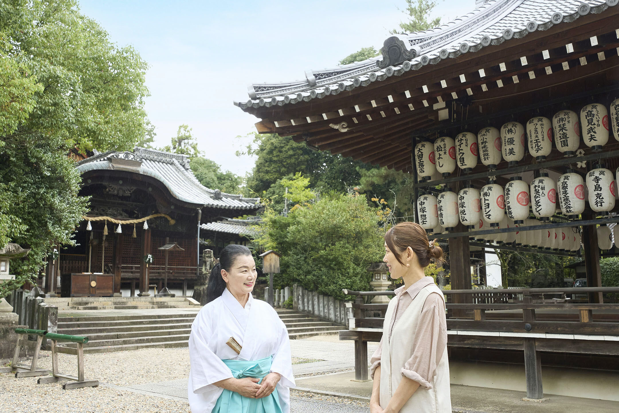 『向日神社』境内で権禰宜の六人部美恵子さんと話す由紀子さん