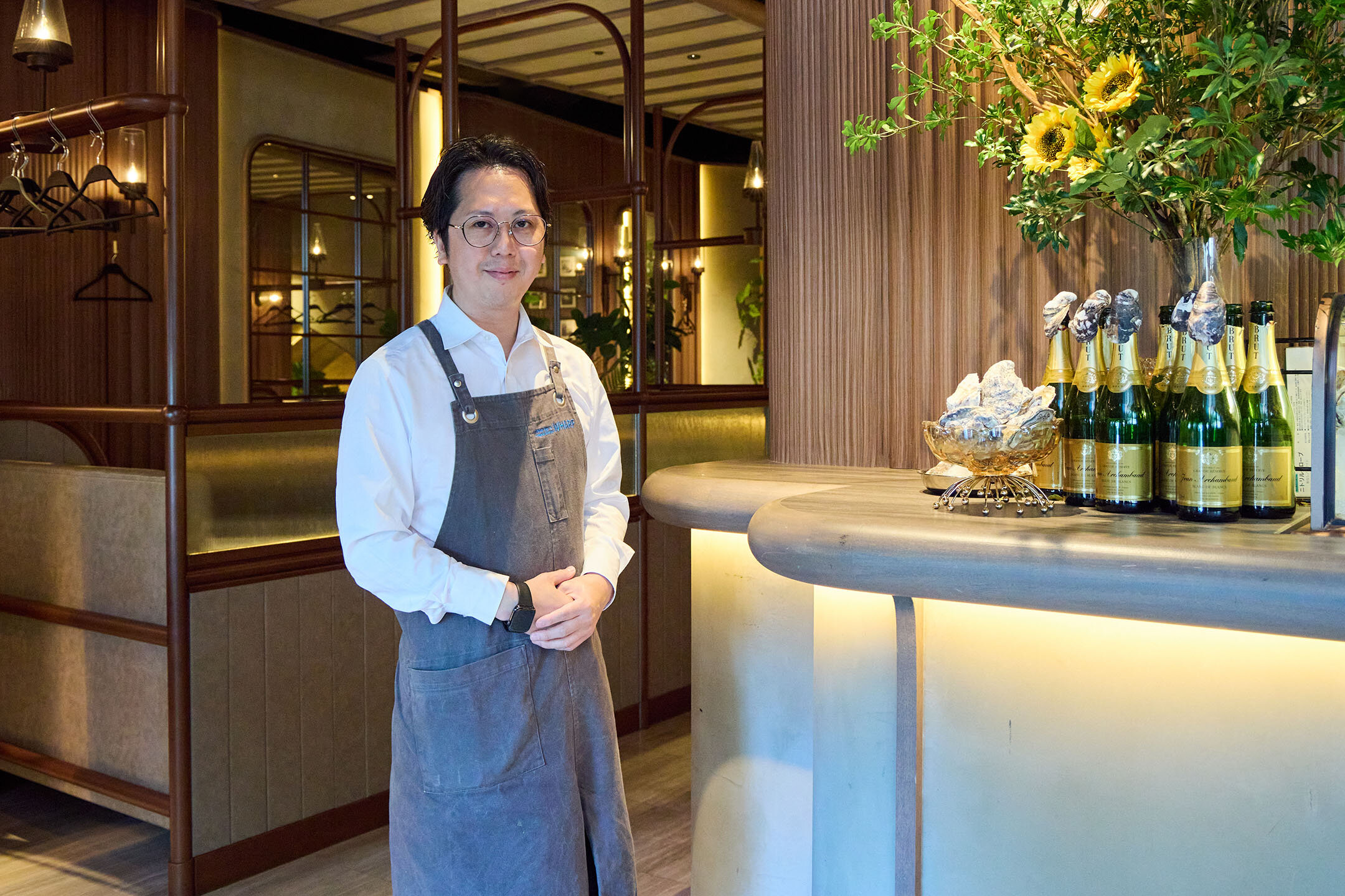 『オイスターバー&ビストロ ワーフ有楽町』の店内。カウンター前に立つ店長の谷口和広さん