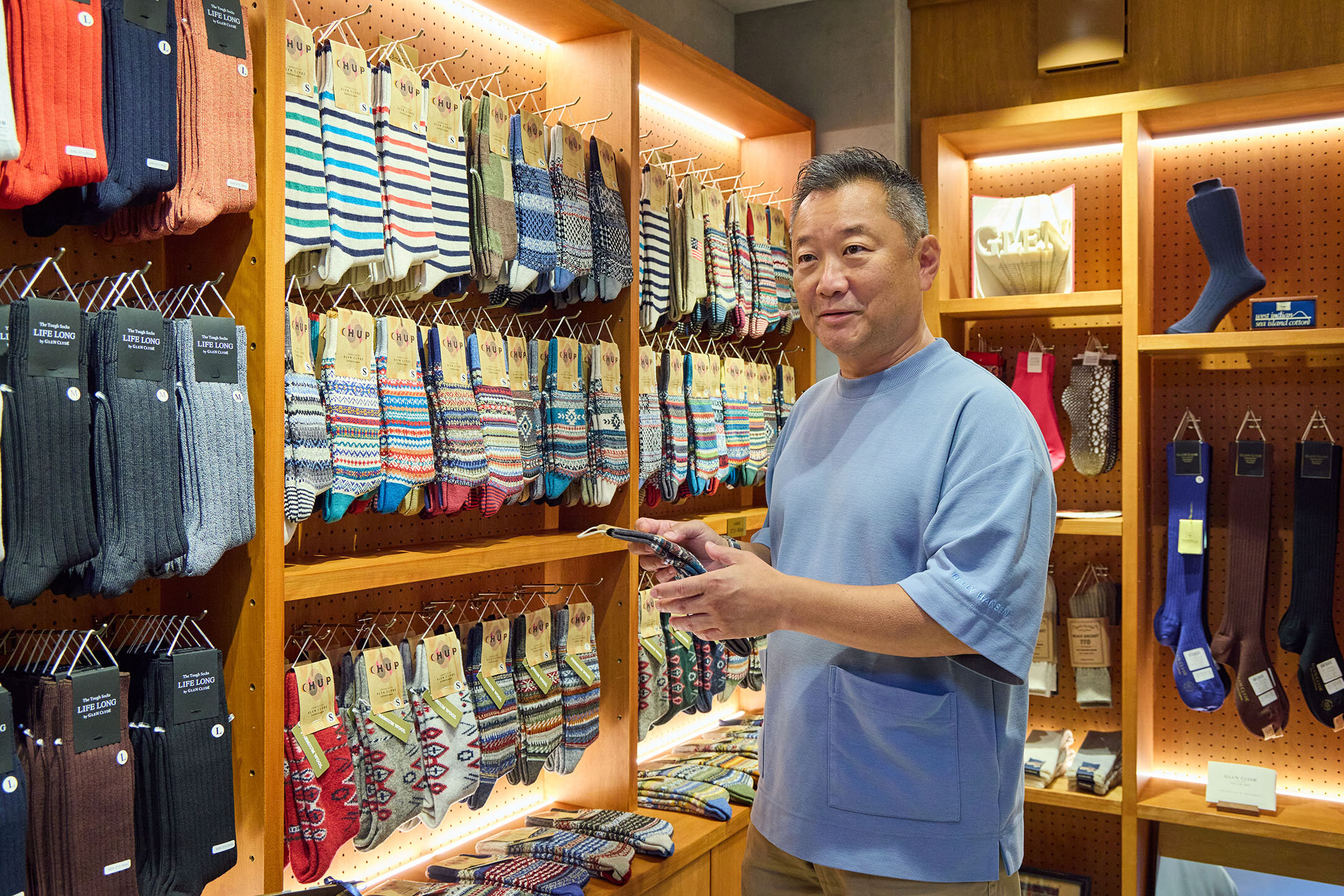 『グレンクライド ソッククラブ トウキョウ』の店内。オーナーの橋本満さんが靴下を手にして話す