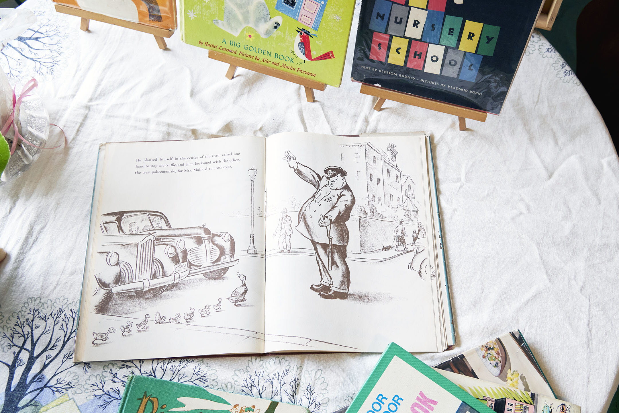 警察官が、かも親子が渡るまで車を止めている様子を描いた絵本の1ページ