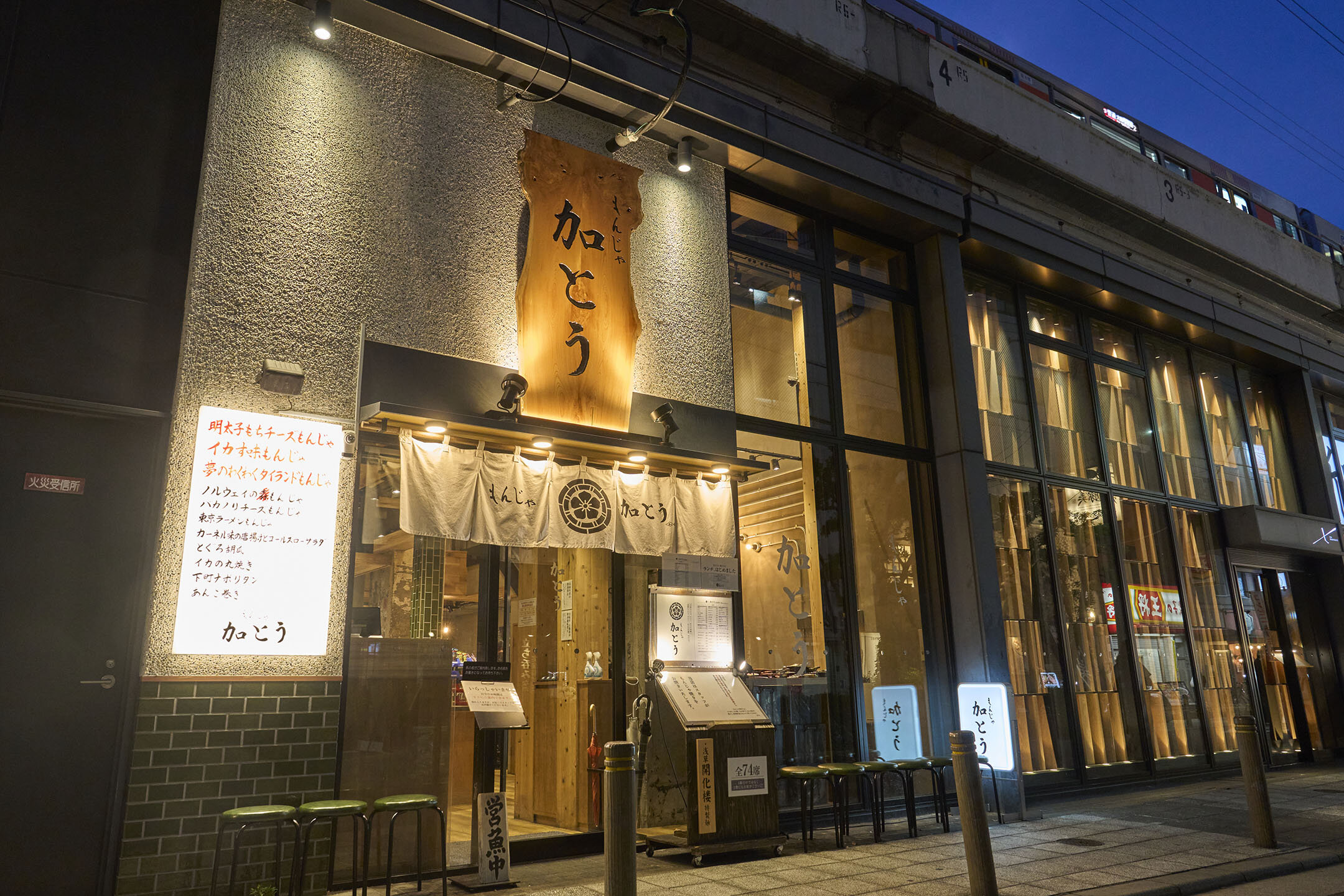 高架下にある「もんじゃ加とう」の外観。入り口には大きな木の看板がかけられている。