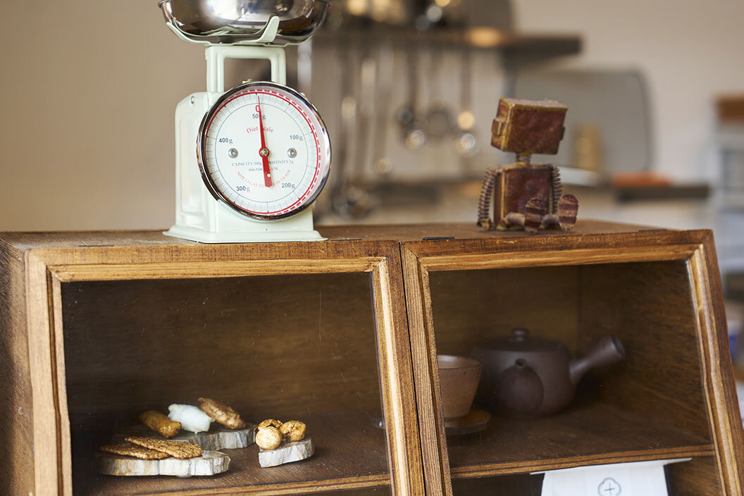 木製ショーケースの上に、おかきの分量を量る秤