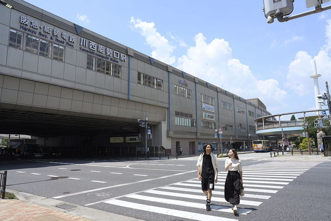 阪急電車の川西能勢口駅前を歩くイケダさん夫妻