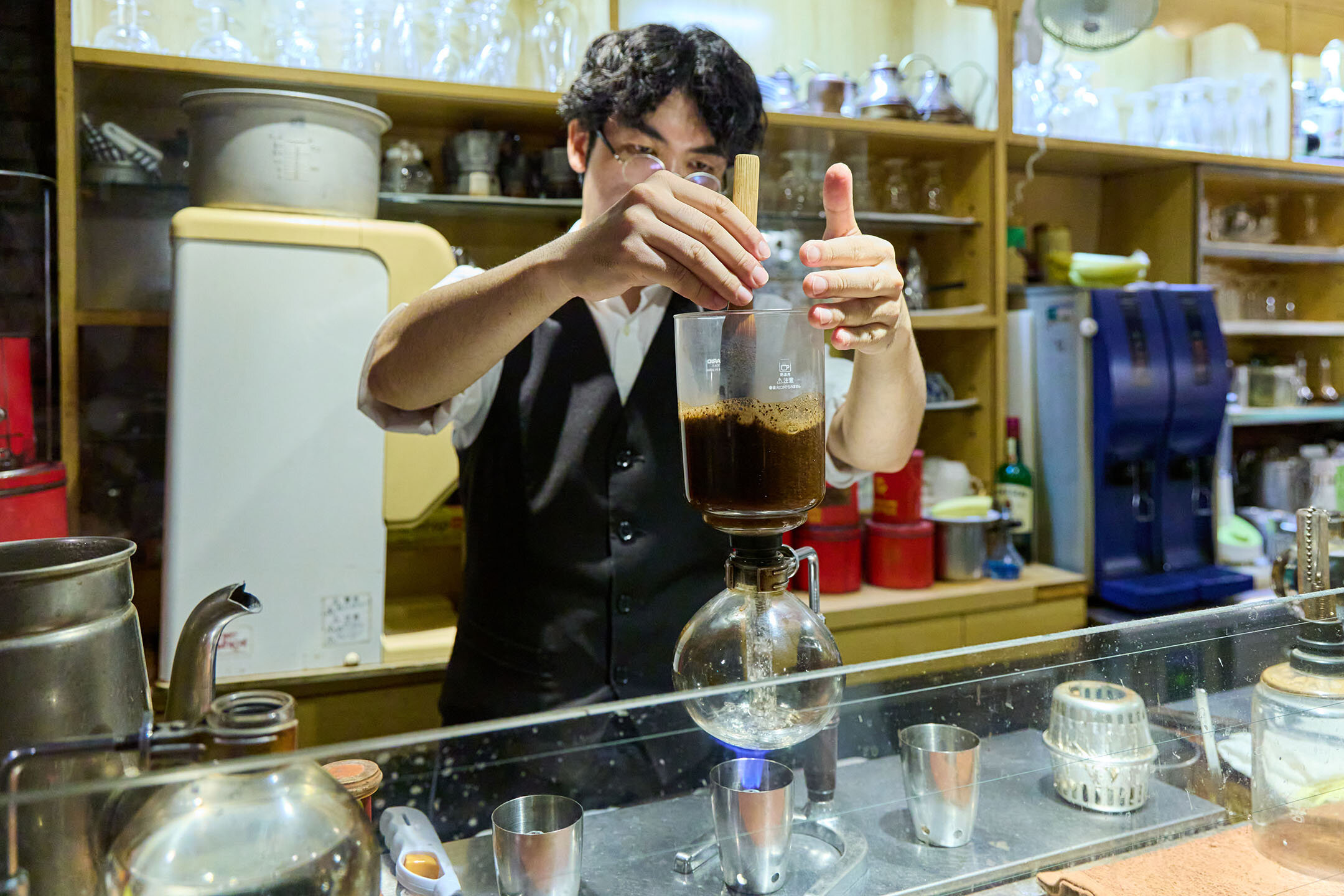 カウンターでサイフォンをするスタッフ