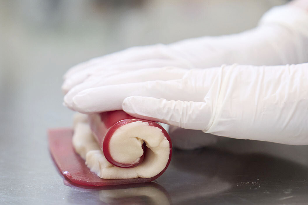 固まった赤い羊羹で白餡を巻き込む様子