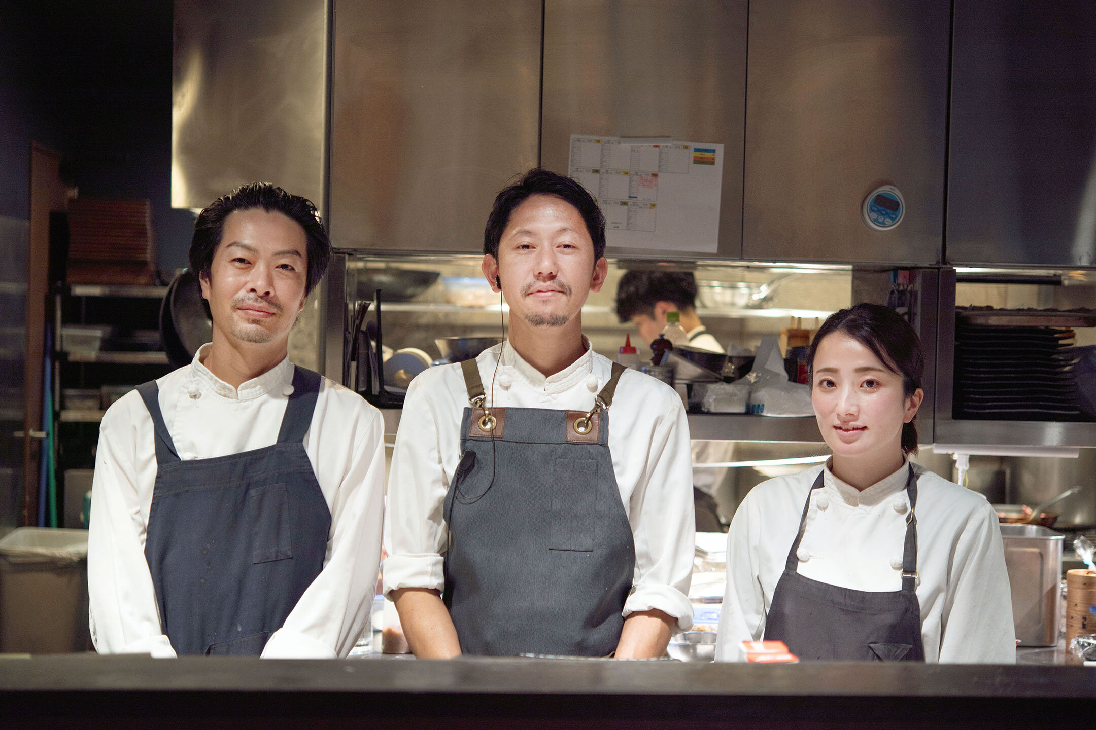 中華、スペイン、パティシエールのシェフ3名が厨房に並ぶ